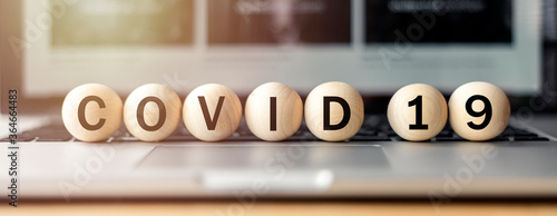 covid 19,word on wooden circle on laptop, affectation after covid-19 pandemic