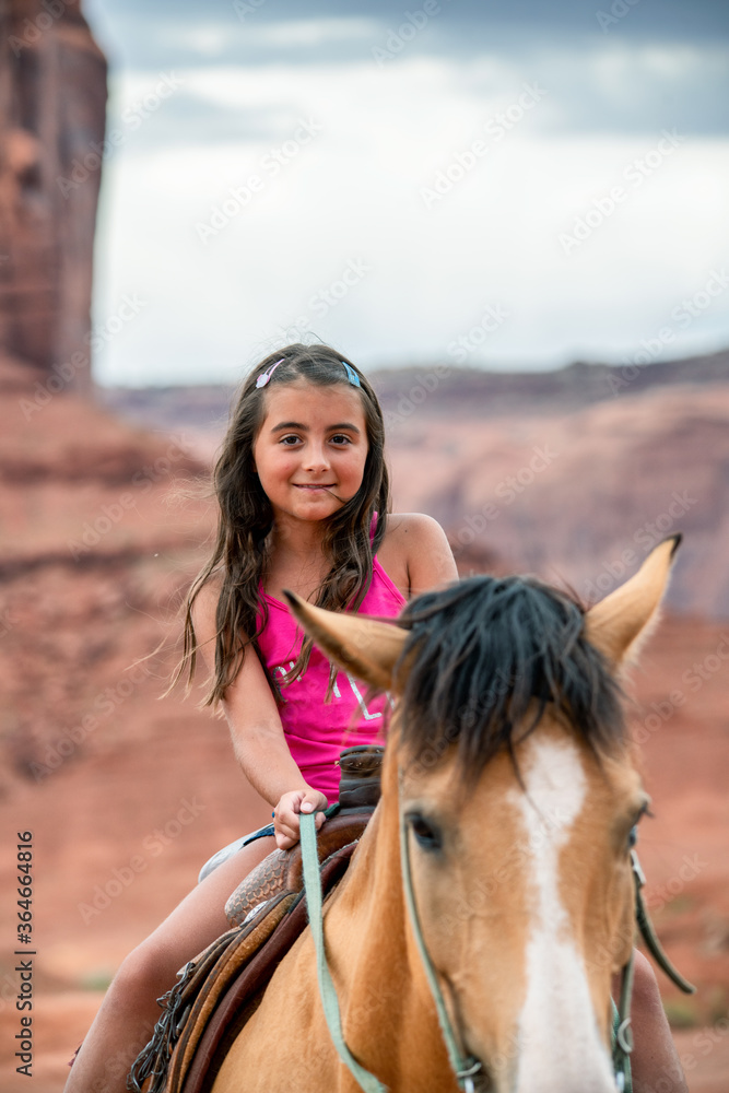 Young girl riding horse in the beautiful Monument Valley Young girl riding horse in the beautiful Monument Valley