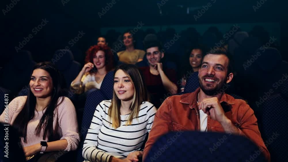 Group of cheerful people laughing while watching movie in cinema. Group of cheerful people laughing while watching movie in cinema.