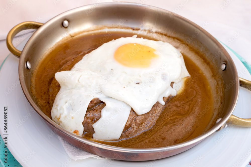 Delicious meat dish from Portugal food - juicy tenderloin steak with fried egg served in thick wine sauce Delicious meat dish from Portugal food - juicy tenderloin steak with fried egg served in thick wine sauce