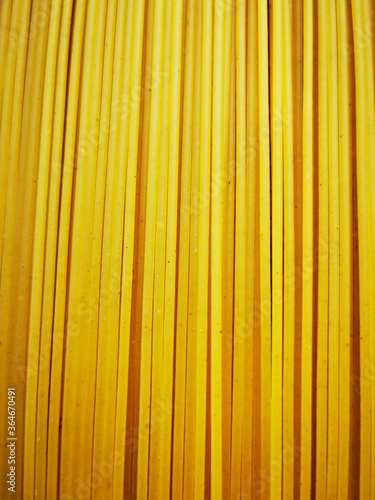Raw pasta spaghetti on a wooden board. Italian pasta.