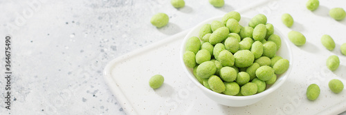 Papier peint Fried peanuts in wasabi in a white bowl on a light gray table