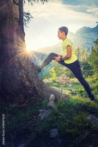 Sport activities in the nature improve health and well-being. Active young athlete running and stretching high in the mountains. Activity in the nature.