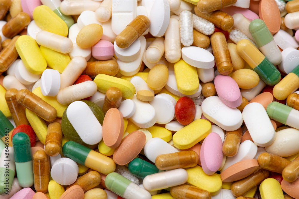 Médicaments de différentes sortes (comprimés, gélules, pilules), tailles et couleurs, entassés en vrac. Concepts de médecine, maladie, traitement, et consommation médicale. Médicaments de différentes sortes (comprimés, gélules, pilules), tailles et couleurs, entassés en vrac. Concepts de médecine, maladie, traitement, et consommation médicale.