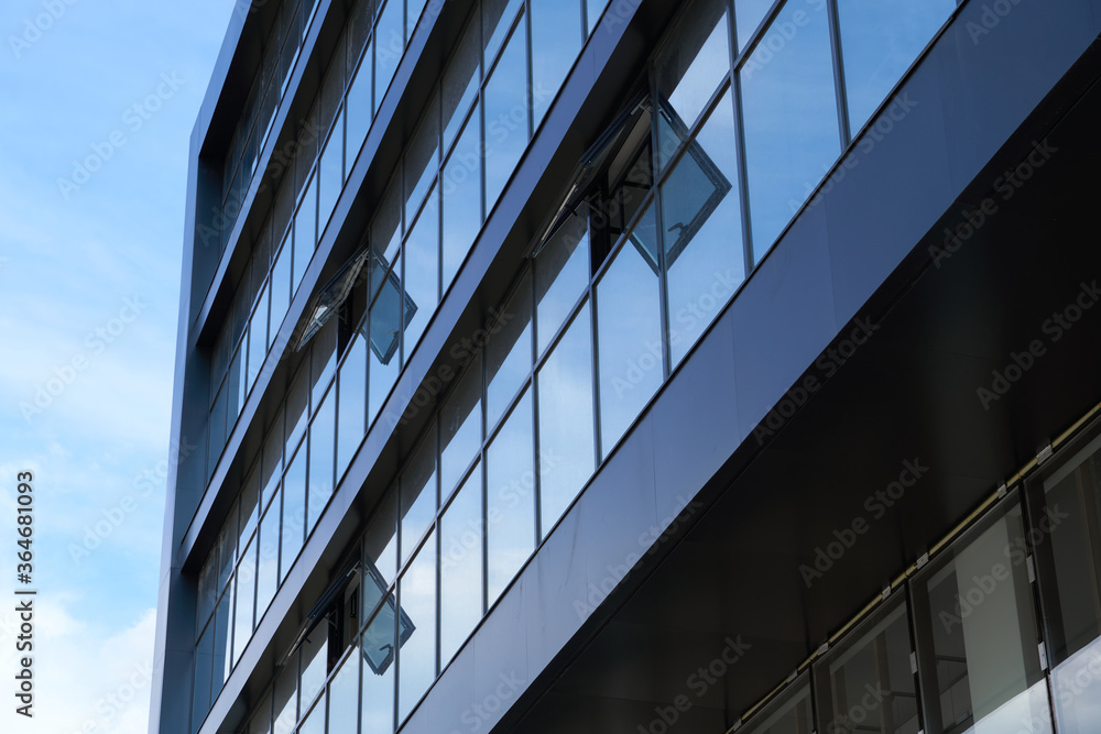 facade of a modern building on a bright Sunny day, blue sky and clouds reflecting in a glass, beautiful exterior of the new building facade of a modern building on a bright Sunny day, blue sky and clouds reflecting in a glass, beautiful exterior of the new building