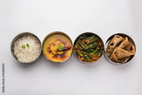 Indian Lunch box or tiffin - Spicy Ladies Finger, dal fry, rice and chapati photo