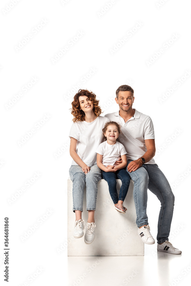 cheerful family smiling and sitting on cube on white cheerful family smiling and sitting on cube on white