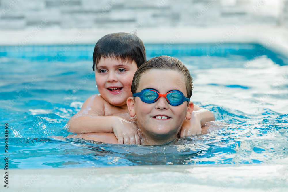 Two funny brothers in the swimming pool