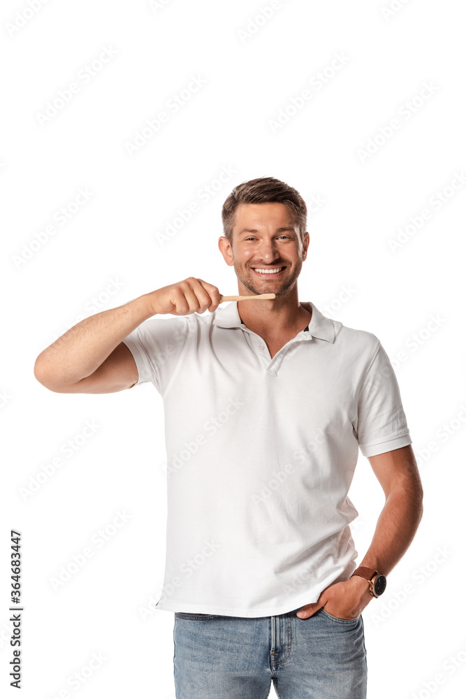 happy man holding toothbrush and standing with hand in pocket isolated on white happy man holding toothbrush and standing with hand in pocket isolated on white