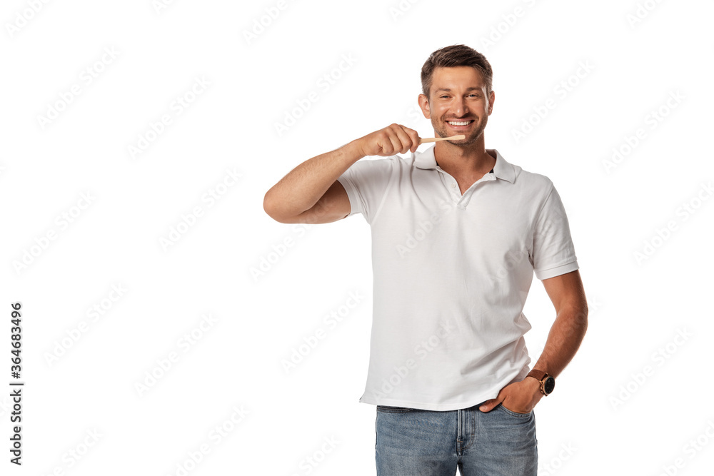 cheerful man holding toothbrush and standing with hand in pocket isolated on white cheerful man holding toothbrush and standing with hand in pocket isolated on white