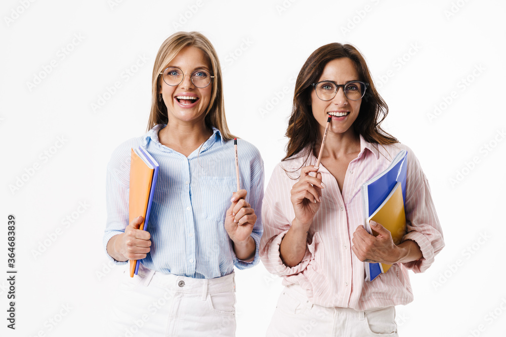 Image of happy women smiling while posing with exercise books Image of happy women smiling while posing with exercise books