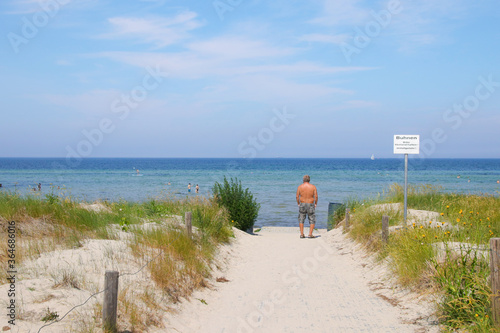 Way to sand beach of the baltic sea island Poel with a warning shield  