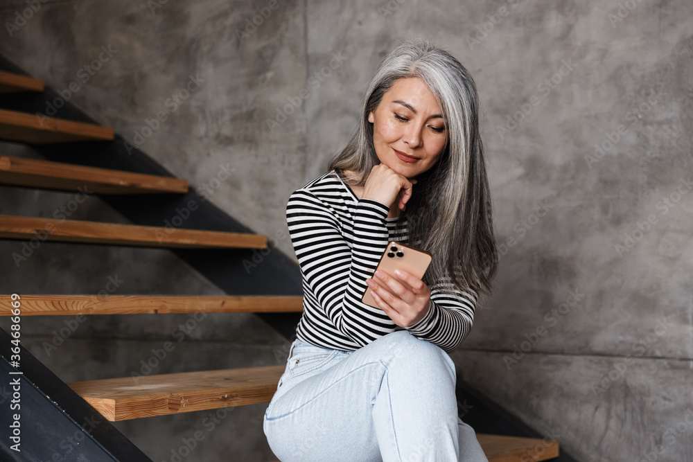 Mature woman sitting on steps indoors at home
