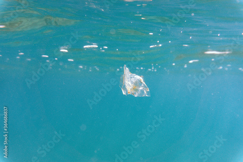 Plastic pollution floating in the sea underwater. Small micro plastics floating underwater in the ocean and polluting its marine life © Alvaro