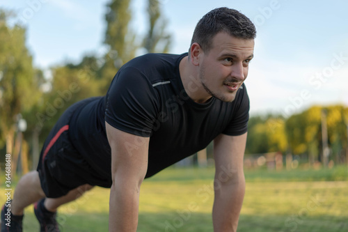 Determined man doing push ups at the outdoor gym.