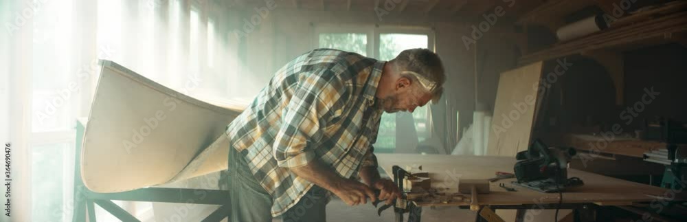 CU Caucasian male shaping canoe paddle with a chisel in his workshop. Boat making hobby, small business owner. Shot on RED Dragon CU Caucasian male shaping canoe paddle with a chisel in his workshop. Boat making hobby, small business owner. Shot on RED Dragon