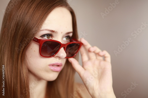 Girl in glasses. Girl portrait in red glasses. Beautiful young curious woman. Woman watching.