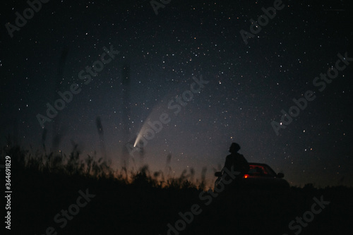 Young man on the background of the starry sky and comet NEOWISE. Comet C / 2020 F3 NEOWISE Observation