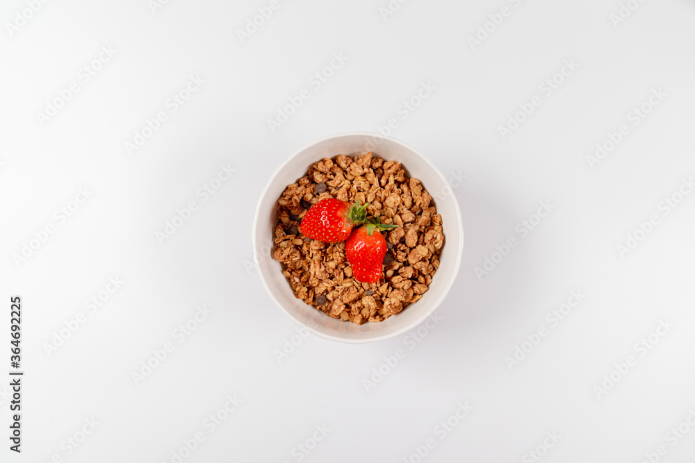 Top view breakfast bowls with granola, milk and organic tasty strawberries in bowl on white background. horizontal space for text Top view breakfast bowls with granola, milk and organic tasty strawberries in bowl on white background. horizontal space for text