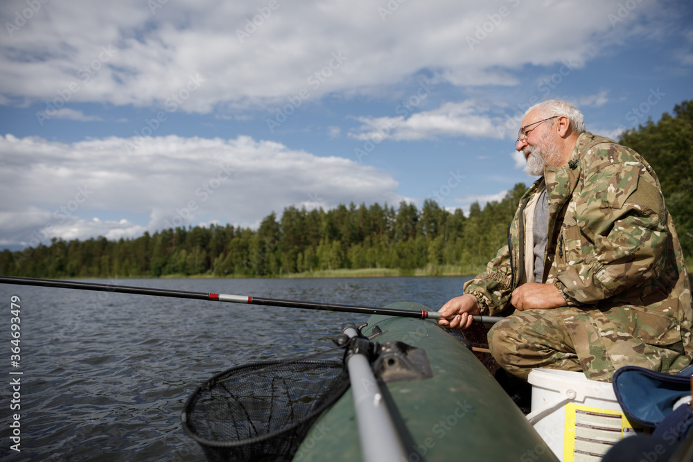 fisherman with fishing rod in inflatable boat fisherman with fishing rod in inflatable boat