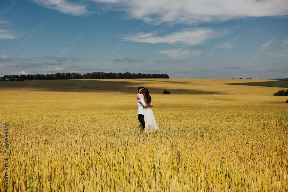 Couple in love on a wheat field at sunny day. Happy young couple enjoying time together in the wheat field at a summer season. Girl riding a guy, funny play. Copy space. Couple in love on a wheat field at sunny day. Happy young couple enjoying time together in the wheat field at a summer season. Girl riding a guy, funny play. Copy space.