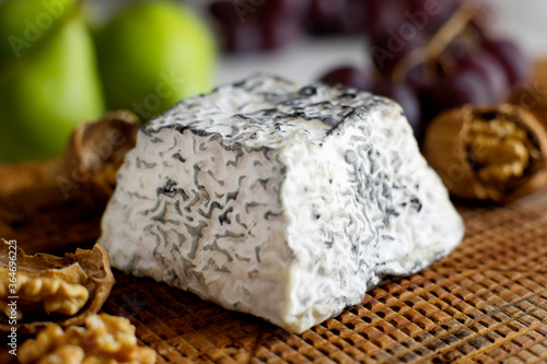 Premium organic goat cheese  on a rustic wooden cheese maker.