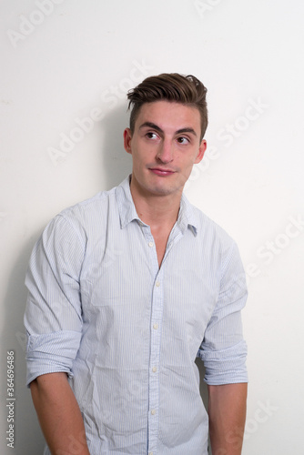 Portrait of young handsome businessman thinking and looking up © Ranta Images