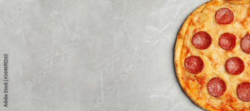 Top view of hot delicious pizza on grey marble table, space for text. Banner design