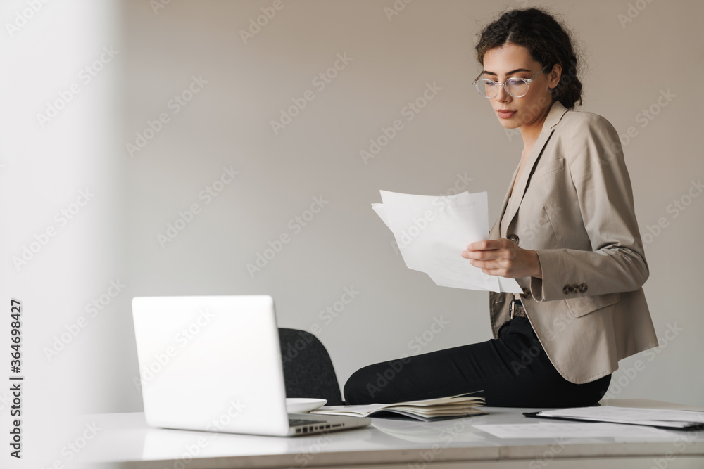 Photo of woman drinking coffee while working with laptop and documents Photo of woman drinking coffee while working with laptop and documents