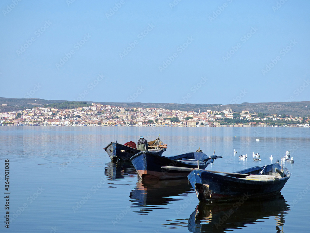 Sardinia view of Sant'Antioco from the lagoon, in the foreground boats typical for fishing in the lagoon, above