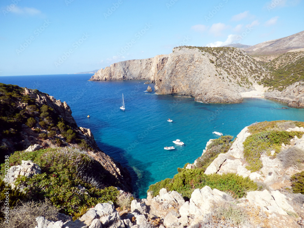 Fototapeta premium Cala Domestica, view of the bay from above along a path, some boats are moored