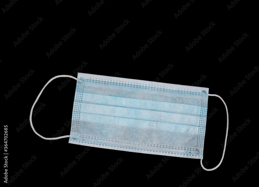 Single use Covid19 use surgical mask isolated on black with copyspace for your comment. Single use Covid19 use surgical mask isolated on black with copyspace for your comment.
