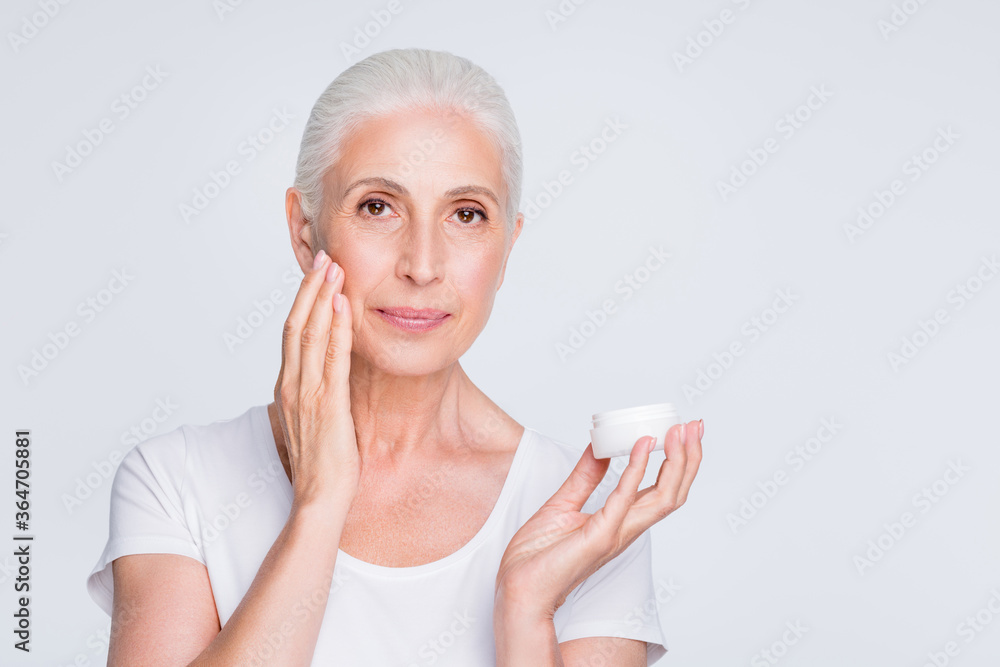 Portrait of attractive lady applying nourishing gel looking at camera wearing stylish trendy t-shirt isolated over white background Portrait of attractive lady applying nourishing gel looking at camera wearing stylish trendy t-shirt isolated over white background