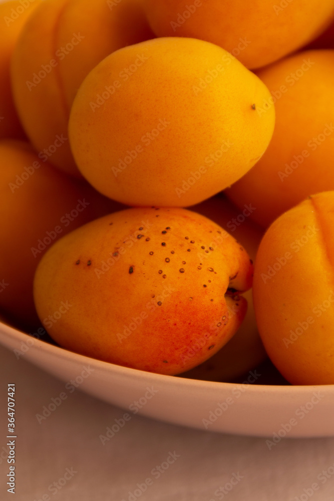 apricots in a plate on a light background in the morning light apricots in a plate on a light background in the morning light