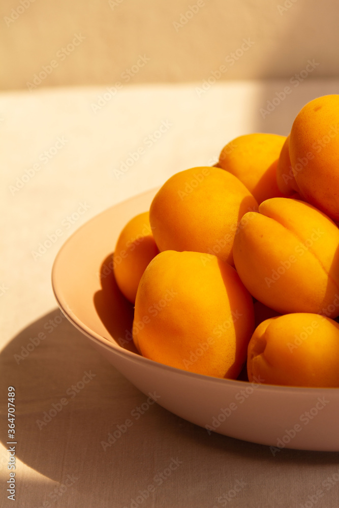 apricots in a plate on a light background in the morning light