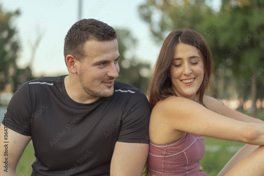 Contemporary young active couple in sportswear doing planks on the floor in front of laptop while watching online workout Contemporary young active couple in sportswear doing planks on the floor in front of laptop while watching online workout