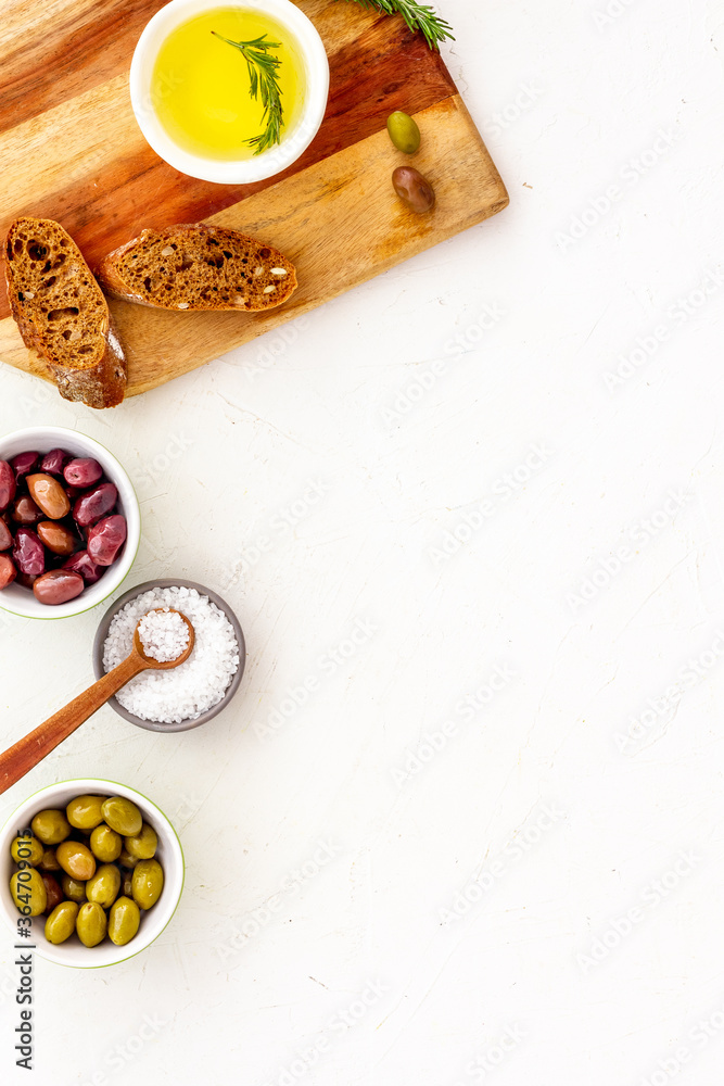 Mediterranean olives near bread on cutting board top view copy space