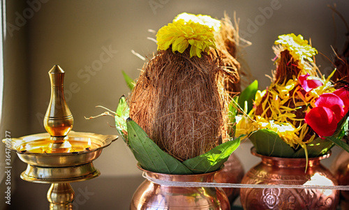 Traditional setting of coconut, betel leaf and flowers placed on brass pot as metaphorical offerings to God during puja in an Indian home photo