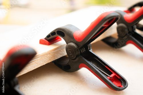 Photos Plastic spring clamps are clamping to glue two pieces of wood