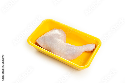 fresh raw chicken leg in yellow foam isolated in white background.