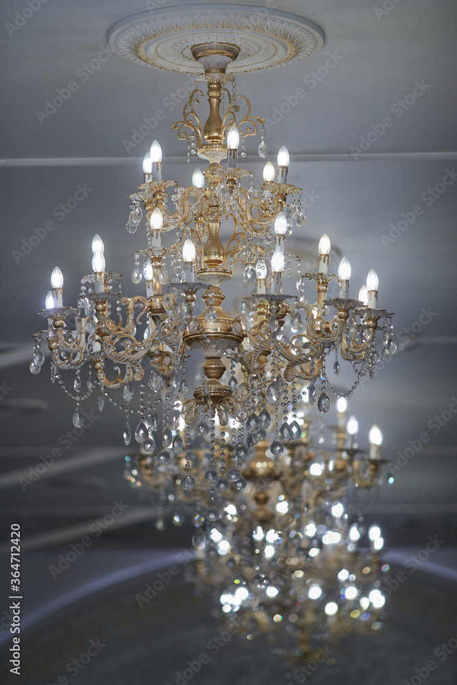 large gilded crystal chandeliers burn in the restaurant hall