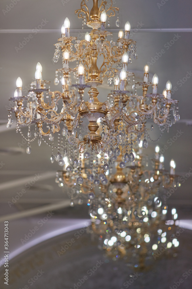 large gilded crystal chandeliers burn in the restaurant hall