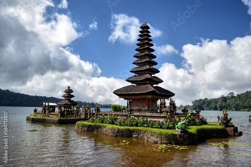 Balinese temple surrounded by mountains  vegetation and a lake.