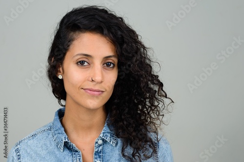 Portrait of young beautiful Hispanic woman with curly hair