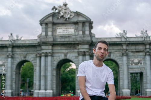 Madrid, Spain / July 13 2020 / Photo of an attractive guy next to Alcala gate in Madrid during sunset	
