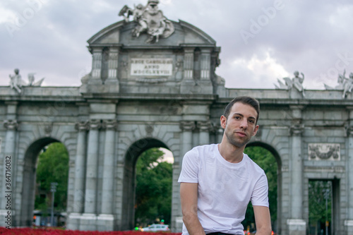 Madrid, Spain / July 13 2020 / Photo of an attractive guy next to Alcala gate in Madrid during sunset	
