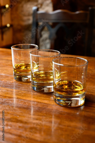 Fototapeta Naklejka Na Ścianę i Meble -  Flight of Scottish whisky, tasting glasses with variety of single malts or blended whiskey spirits on distillery tour in pub in Scotland