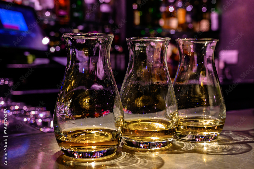 Flight of Scottish whisky, tasting glasses with variety of single malts or blended whiskey spirits on distillery tour in pub in Scotland Flight of Scottish whisky, tasting glasses with variety of single malts or blended whiskey spirits on distillery tour in pub in Scotland