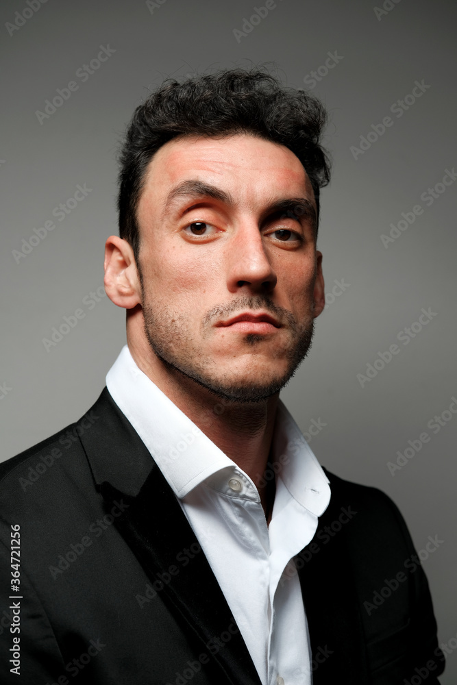 Close up portrait of a man 30-34 years old in a white shirt and a black jacket on a gray background. Close up portrait of a man 30-34 years old in a white shirt and a black jacket on a gray background.