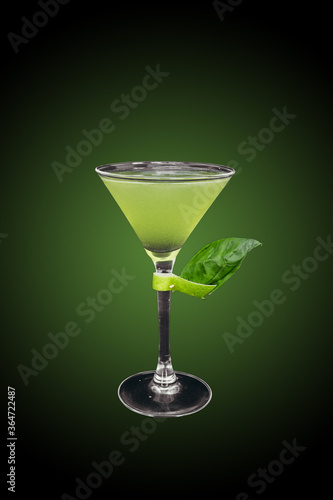 Gin basil smash cocktail isolated on green gradient